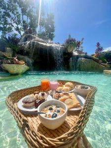 a basket of food in the water next to a fountain at Lara's Home Suites in Capitólio