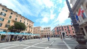 uma rua da cidade com prédios e pessoas andando por aí em Tra centro e mare - Intero appartamento con parcheggio em Savona