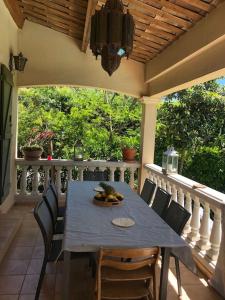 una mesa y sillas sentadas en un porche con una mesa en Villa spacieuse avec piscine proche de la mer en Biot
