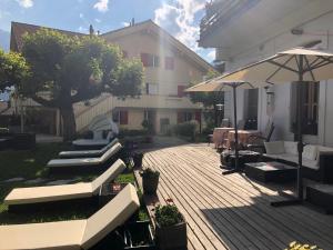 una terraza al aire libre con sombrilla y un edificio en Apartment with great view at Residence Brunner en Wengen