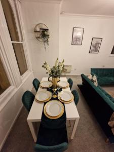 uma mesa de jantar com pratos e flores em Two Bedroom Mansion House Apartment By AZ Luxury Stays Newmarket With Parking And WiFi em Newmarket