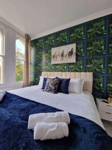 een slaapkamer met een groot bed met blauwe muren bij Two Bedroom Mansion House Apartment By AZ Luxury Stays Newmarket With Parking And WiFi in Newmarket