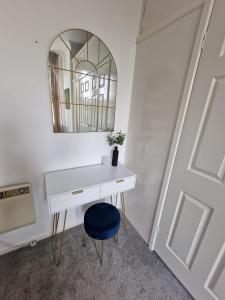 a white desk with a blue chair and a mirror at Two Bedroom Mansion House Apartment By AZ Luxury Stays Newmarket With Parking And WiFi in Newmarket