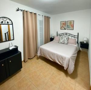 een slaapkamer met een bed, een dressoir en een spiegel bij Mi refugio in San Sebastián de la Gomera