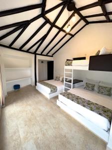 two beds in a room with wooden ceilings at Estudia y trabaja sin límites en Hacienda Loretto con Starlink!! in Silvania