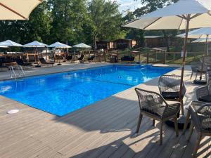 a large swimming pool with chairs and umbrellas at Buddy's Harbor in Lake Ozark
