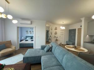 uma sala de estar com um sofá azul e um quarto em Apartament 32 NOWA WIEJSKA Olecko Mazury Garbate em Olecko