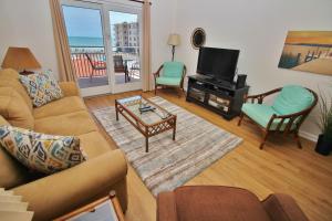 a living room with a couch and a tv at Sea Coast Gardens II 317 in New Smyrna Beach