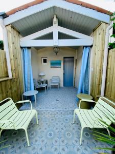Chaucre的住宿－Charming house close to the Plage des Huttes，庭院设有白色椅子和蓝色地板