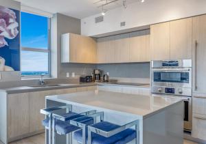 una cucina con ampia isola e sgabelli blu da bar di HYDE BEACH HOUSE #2408 THREE-BEDROOM, WATERFRONT, OCEAN AND INTERCOSTAL VIEW, ROOFTOP POOL, 5 MiN WALK TO BEACH a Hollywood