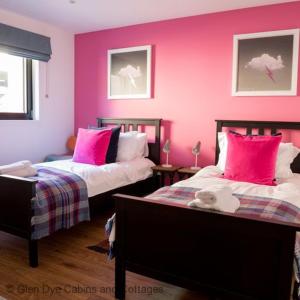 a bedroom with two beds with pink walls at Number 5 Steading Cottage in Banchory