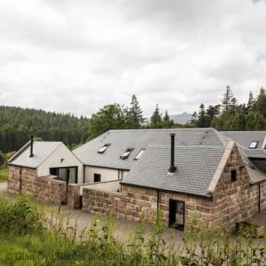 a stone house with a stone wall and roofs at Number 5 Steading Cottage in Banchory