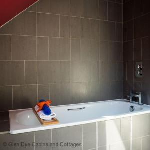 a bath tub with a toy sitting on top of it at Number 5 Steading Cottage in Banchory