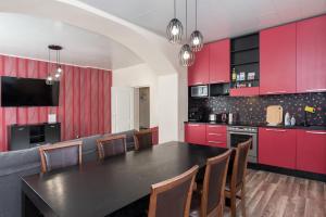 a kitchen with red cabinets and a black table and chairs at Vallikääru apartement in Pärnu