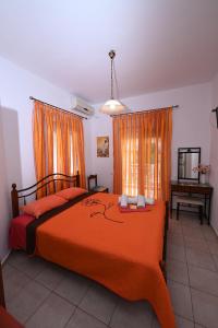 a bedroom with a bed with an orange bedspread at Four Seasons 1 in Paralia Katerinis