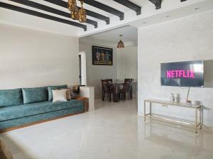 a living room with a blue couch and a tv at Airport Oasis Stay 15min to Rabat in Salé