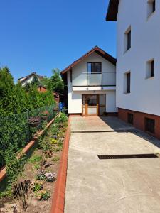 une maison avec un jardin en face dans l'établissement Maly domek, à Szczecinek