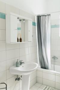 La salle de bains blanche est pourvue d'un lavabo et d'une douche. dans l'établissement Grey House, à Chorafakia