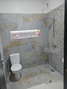 uma casa de banho com um WC e uma cabina de duche em vidro. em Your Airport Oasis Resort 15 Minutes from Rabat em Salé