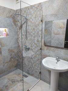 a bathroom with a sink and a glass shower at Your Airport Oasis Resort 15 Minutes from Rabat in Sale