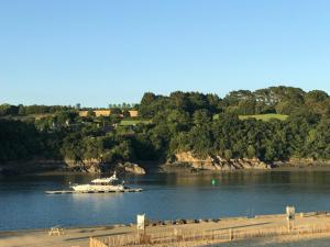 a boat is docked on a river with trees at Les Portes de Tréguier - Gites de charme in Tréguier