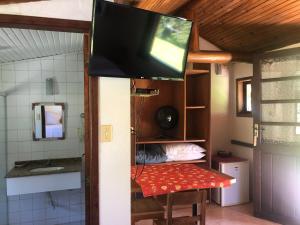 a tv hanging from the ceiling of a room with a bathroom at Pousada Mariza in Nova Friburgo