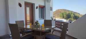 uma sala de jantar com uma mesa e cadeiras numa varanda em Holiday Home Triovasalos Milos em Triovasálos