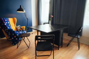 a black table and chairs in a room at Poorbaltics Studio in Liepāja +2 photos