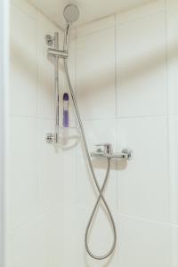 a shower with a shower head in a bathroom at Poorbaltics Studio in Liepāja