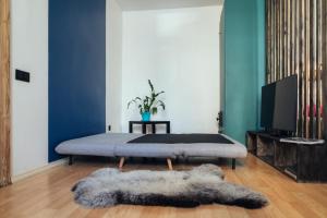a bedroom with a bed and a television and a rug at Poorbaltics Studio in Liepāja
