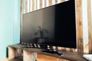 a flat screen tv sitting on a wooden stand at Poorbaltics Studio in Liepāja