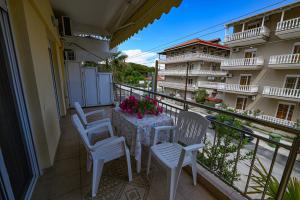 a balcony with two chairs and a table with flowers at Four Seasons 1 in Paralia Katerinis