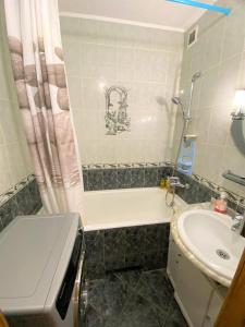 a bathroom with a sink and a tub and a toilet at Просторі апартаменти поруч з метро Лівобережна in Kyiv