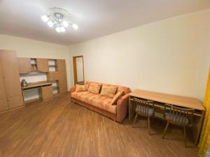 a living room with a couch and a table at Просторі апартаменти поруч з метро Лівобережна in Kyiv