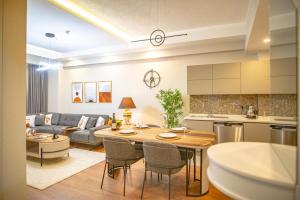 a kitchen and living room with a table and a couch at Sirius Town by AntalyaSuites in Antalya