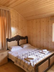 um quarto com uma cama num quarto de madeira em Hotel Okatsia სასტუმრო ოკაცია em Gordi
