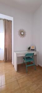 een bureau met een stoel en een magnetron in de kamer bij Piso de 2 habitaciones a 200 metros de la playa in Las Palmas de Gran Canaria