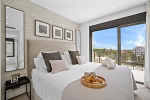 ein Schlafzimmer mit einem großen Bett mit einer Obstschale darauf in der Unterkunft VACATION MARBELLA I Villa Iniesta, Golf Community, Brand-New Built, Infinity Pool in Estepona