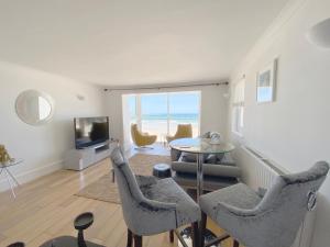 a living room with a table and chairs and a television at Carbis Bay and Spa Hotel in St Ives