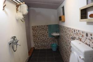 a small bathroom with a toilet and a sink at K - Den Homestay & Cafe in Kurseong