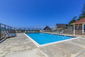 a swimming pool on a patio with chairs around it at Olivia's Rose in Lincoln City