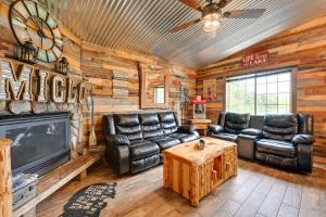 ein Wohnzimmer mit Ledermöbeln und einem TV in der Unterkunft Lakeside Cabin with Fire Pit Near Pine Point Park! in Holcombe