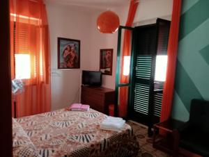 1 dormitorio con 1 cama y TV en Cala Licina, en Agropoli