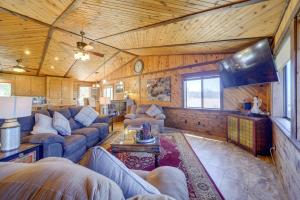 a living room with couches and a flat screen tv at Payson Cabin with Deck Near Hiking, Fishing and More! in Payson