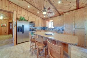 a kitchen with a large island with a refrigerator at Payson Cabin with Deck Near Hiking, Fishing and More! in Payson