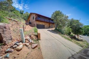 a house on the side of a hill with a driveway at Payson Cabin with Deck Near Hiking, Fishing and More! in Payson
