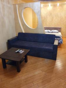 uma sala de estar com um sofá azul e uma mesa em 1-комнатная квартира ВИП уровня посуточно в Ужгороде. ул.И.Франка. em Uzhhorod