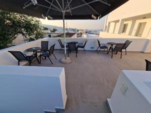 a patio with tables and chairs and an umbrella at Aerial Apartment in Karterados