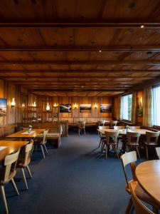 uma sala de jantar com mesas e cadeiras de madeira em Landgasthof Hotel Menzberg em Menzberg
