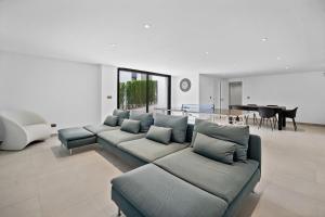 ein Wohnzimmer mit einem Sofa und einem Esszimmer in der Unterkunft VACATION MARBELLA I Villa Iniesta, Golf Community, Brand-New Built, Infinity Pool in Estepona